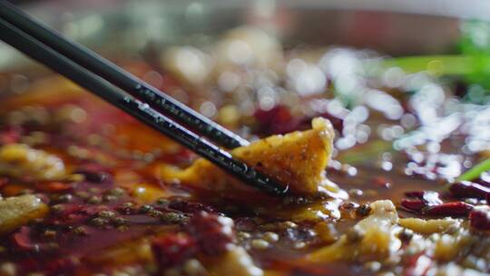 筷子夹起麻辣鱼片川味火锅