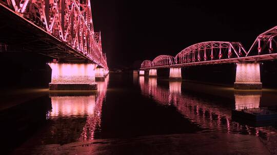 辽宁丹东鸭绿江铁桥夜景灯光倒影水面