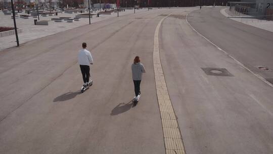 公路上玩滑板车男人和女人