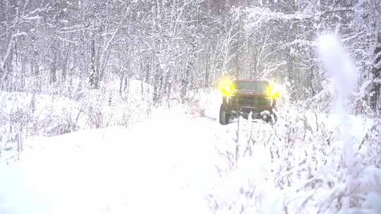 雪地树林中行驶的红色越野车