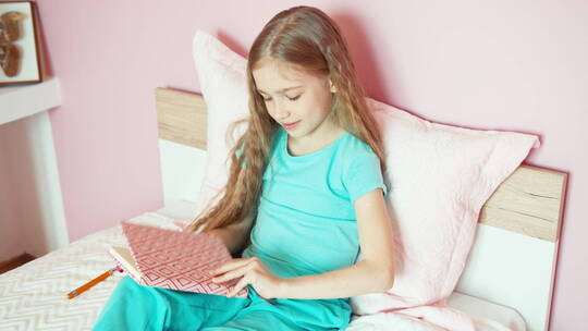 女生坐在床上看书写字视频素材模板下载