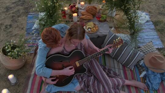 情侣在海边弹吉他