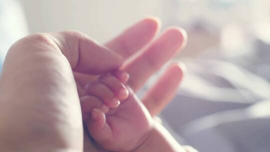 母亲牵着新生儿婴儿的手
