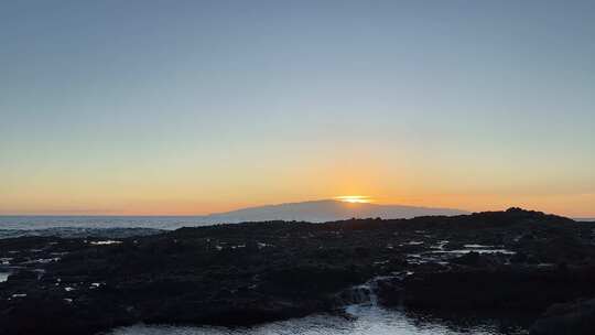 日落时海岸岩石地层上的破浪