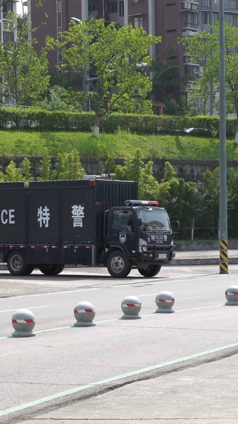 街道上行驶的车和停放的特警车辆