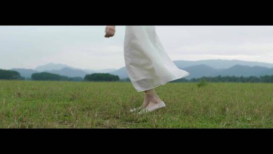 白色连衣裙女子在草原上旋转跳舞舞步特写视频素材模板下载
