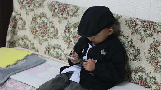 小男孩沙发上玩手机画面