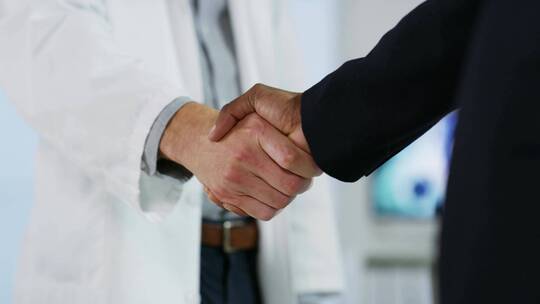 医生在医院与一位商人握手