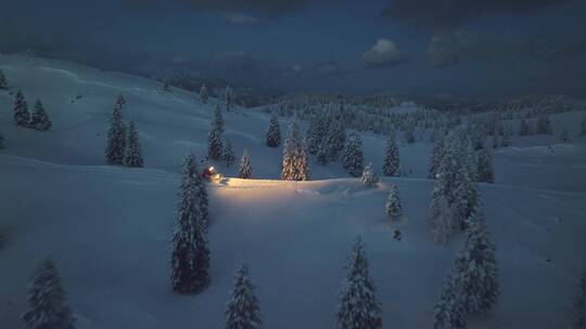 航拍夜幕下的雪山里行驶的汽车
