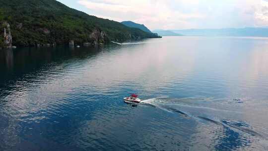 航拍马其顿海岸和船只进入海湾。奥赫里德湖周围的悬崖和美丽的水