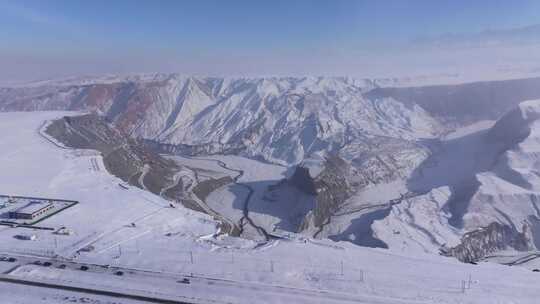 航拍新疆冬季安集海大峡谷红色山脉雪山河流