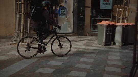 送货员骑着自行车在城市街道穿梭