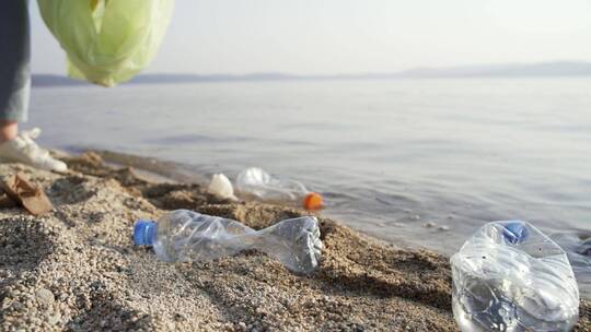 在海边沙滩做环保分拣清理垃圾的志愿者