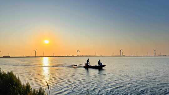 夕阳下湖面渔船剪影