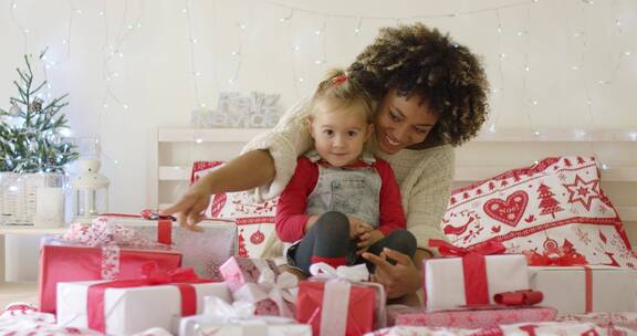 女儿和母亲坐在床上看圣诞礼物