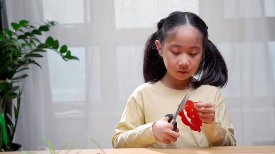 认真玩剪纸游戏的中国女孩视频素材模板下载