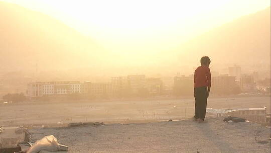 沙尘暴中男孩眺望喀布尔阿富汗