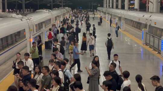 夜晚高铁站站台排队候车的旅客