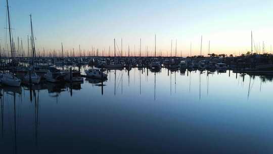 清晨日出的高处景色，在一个平静的船港，挤满了休闲船只