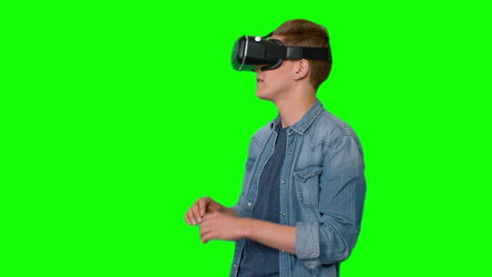 绿屏上戴虚拟现实耳机的年轻人