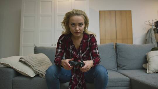 女人坐在沙发上打游戏视频素材模板下载