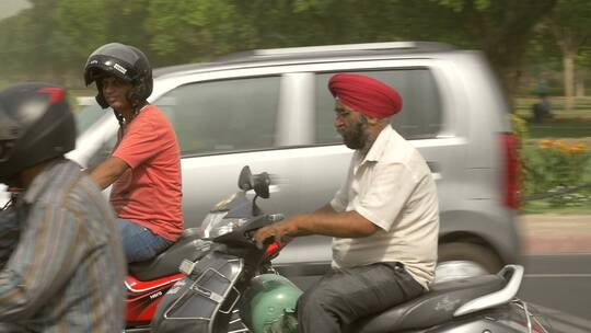 印度人在城市公路上骑摩托车
