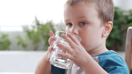 小男孩在拿着水杯喝水