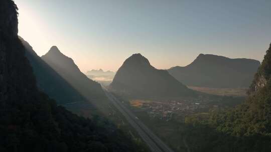 日出时分桂林喀斯特山峰间穿行的高速公路