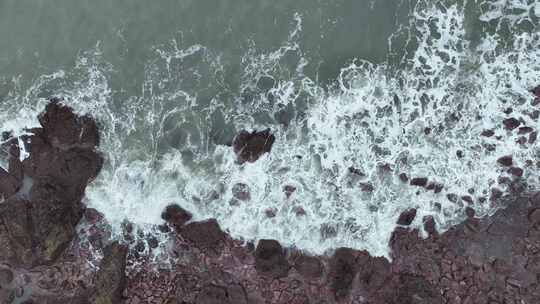 海岸礁石沙滩海水拍打礁石阴天海滩海浪冲刷视频素材模板下载