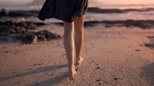 女人赤脚在海滩行走