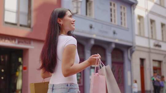 混血妇女拿着购物袋在户外市场散步。