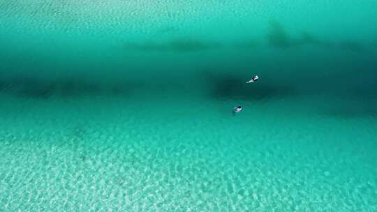 航拍尤卡坦半岛海滩情侣在海边划船游泳玩乐