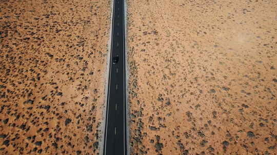无人机跟随银色汽车沿着干燥的美国沙漠景观公路行驶视频素材模板下载