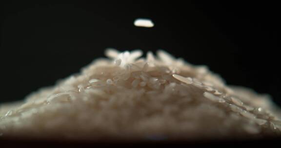 大米缓慢散落在米堆上的特写慢镜头
