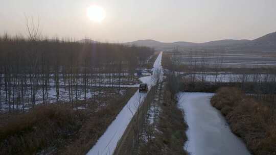 冬天吉普车行驶在北方乡村积雪白桦林小道