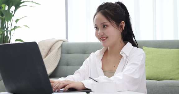 年轻女性在家使用电脑工作