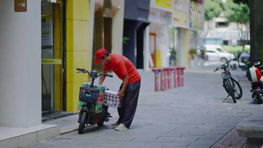 外卖快递员搬运货物矿泉水载货电动车