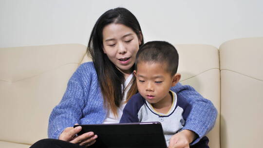中国女士小朋友居家看书看手机看平板学习