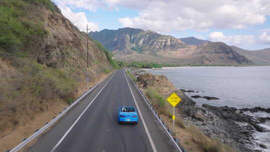 空中蓝色敞篷车驾驶沿海公路到山脉瓦胡岛美