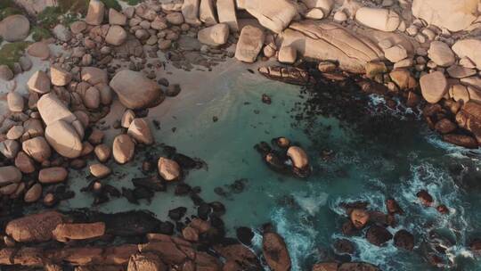 无人机拍摄水冲击海边的大石头