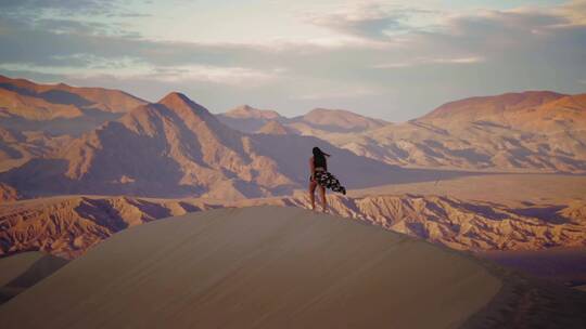 女人走在沙漠山丘上