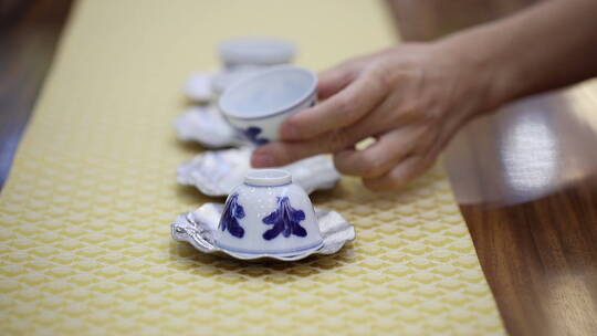 美女在茶台上整理茶杯素材