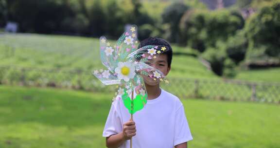 （慢镜）小孩拿着风车草坪玩耍快乐的童年