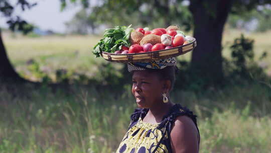 非洲女人头顶蔬菜篮子接孩子放学回家