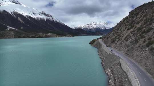 雪山下的公路与碧绿湖水风景