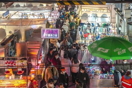 热闹夜市中人群穿梭逛摊购物的场景