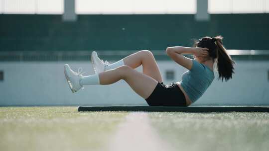 女子户外草坪做仰卧起坐