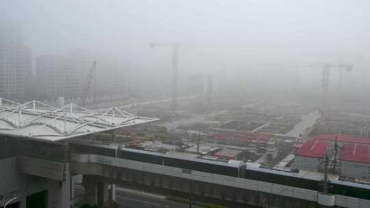 上海外高桥秋天晨雾地铁站与建设工地塔吊