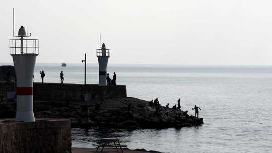 人们走下海堤去海湾钓鱼