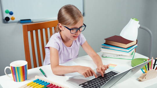 女孩在笔记本电脑键盘上打字